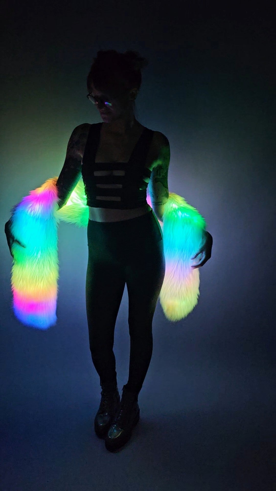 Woman wearing a white faux fur Glow Worm scarf with multicolor LEDs.