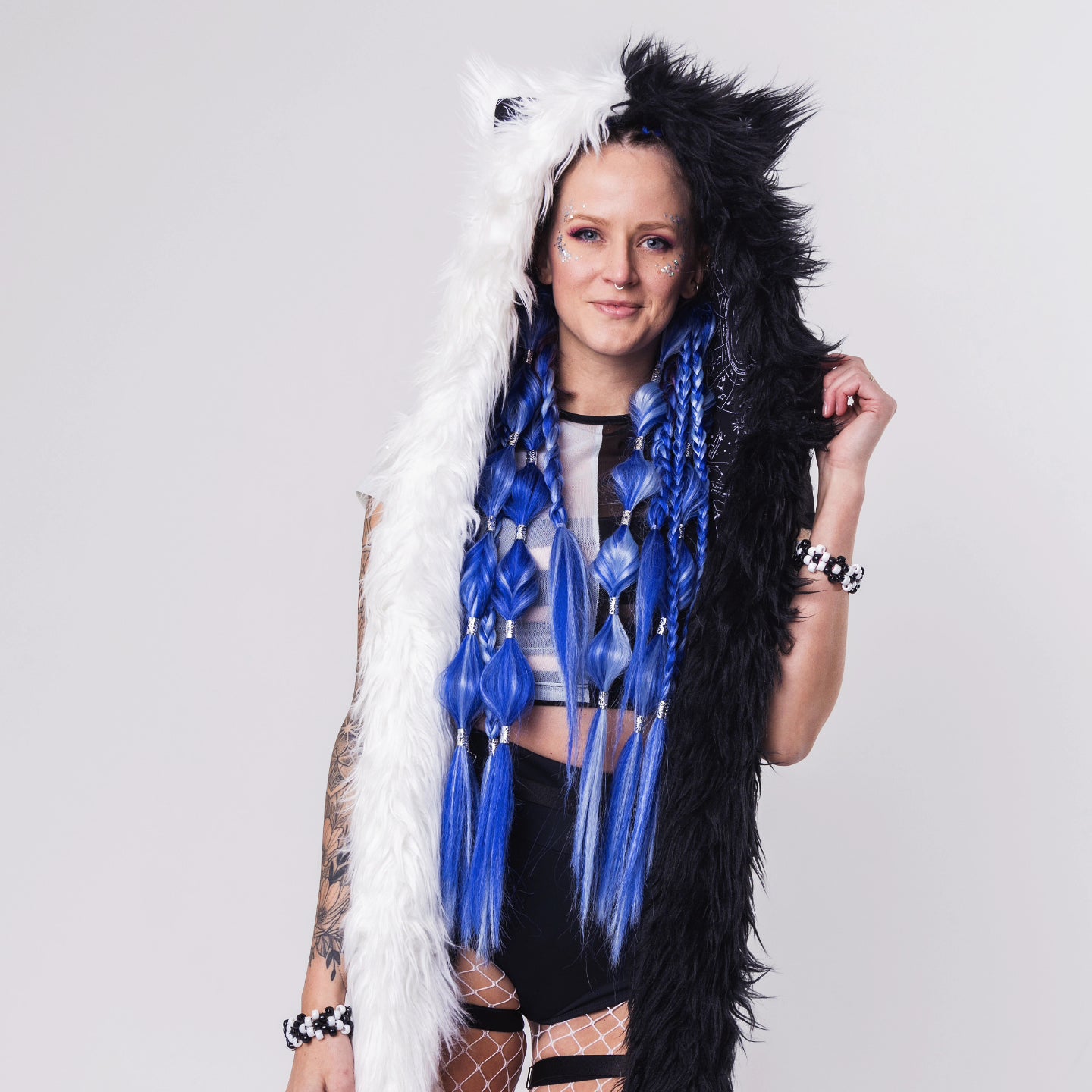 Woman wearing a faux fur tentacle hood with animal ears that is half white and half black