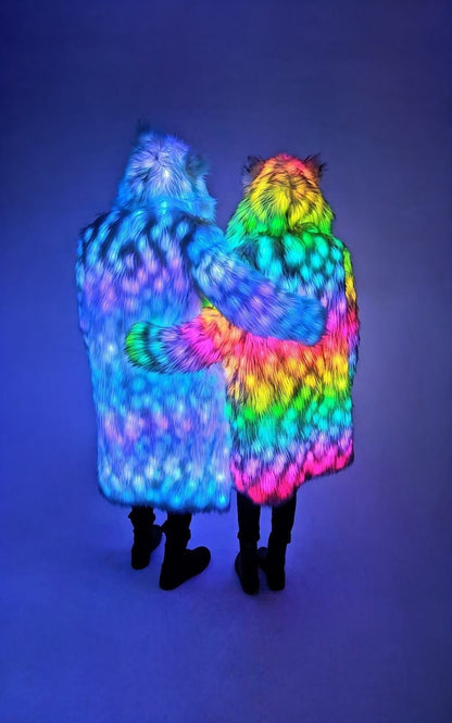 Two people wearing colorful, illuminated fur coats against a dark background