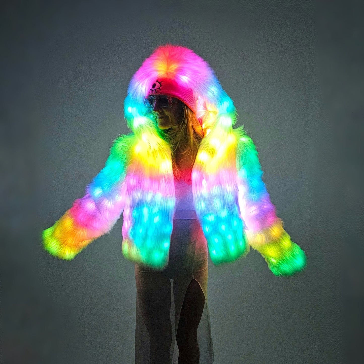 Person wearing a colorful LED wig against a dark background