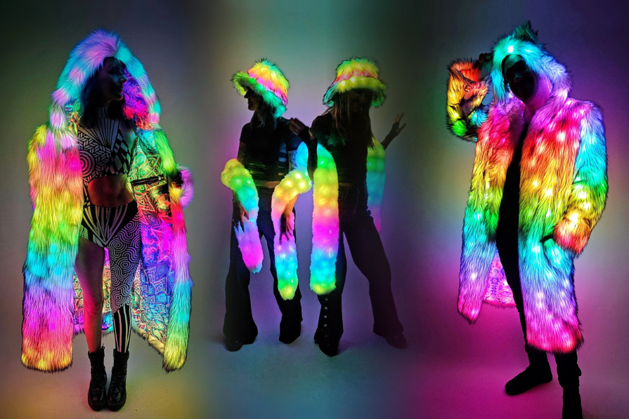 Four people wearing colorful, illuminated outfits against a dark background