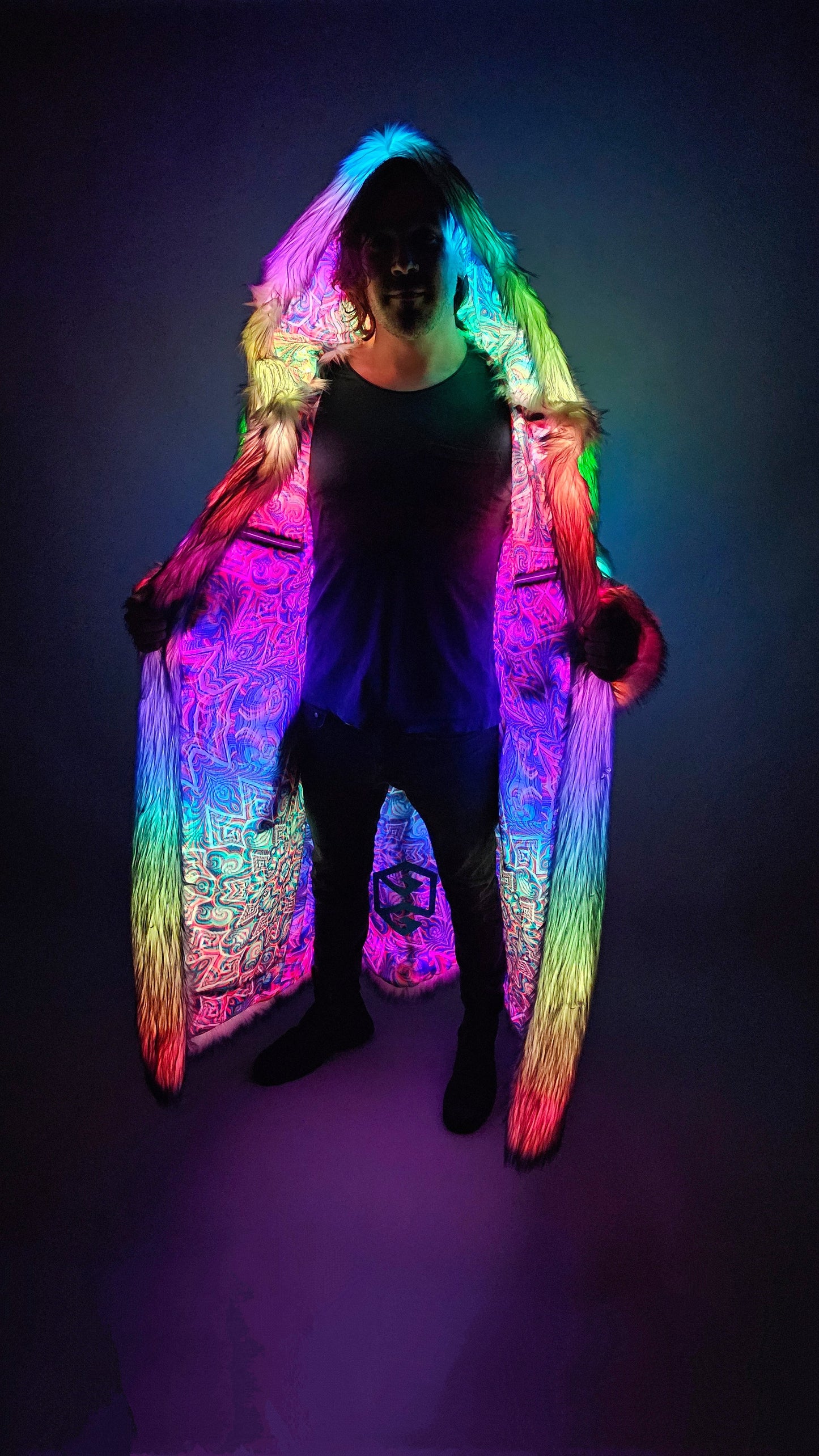 Man wearing a long faux fur coat with multicolor LEDS and psychedelic lining.