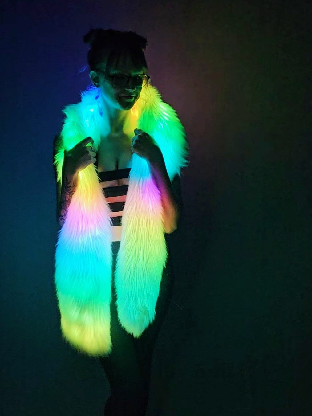 Woman wearing a white faux fur Glow Worm scarf with multicolor LEDs.