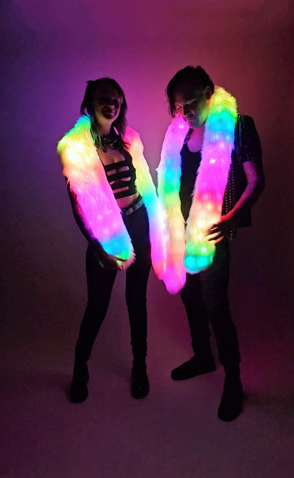 Two people wearing LED scarves against a dark background
