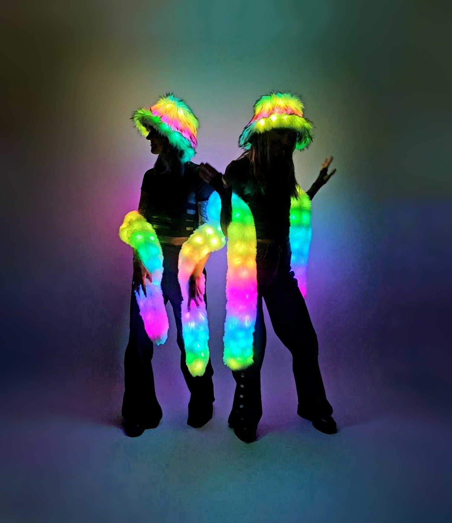 Two people wearing colorful LED costumes against a dark background