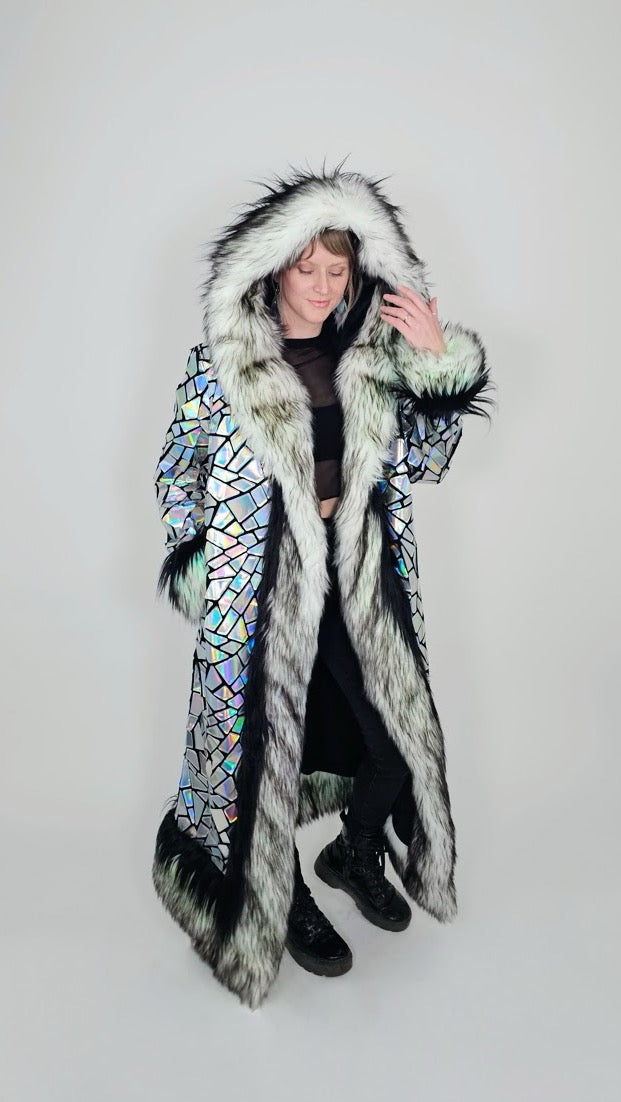 Person wearing a long, colorful coat with a hood on a white background