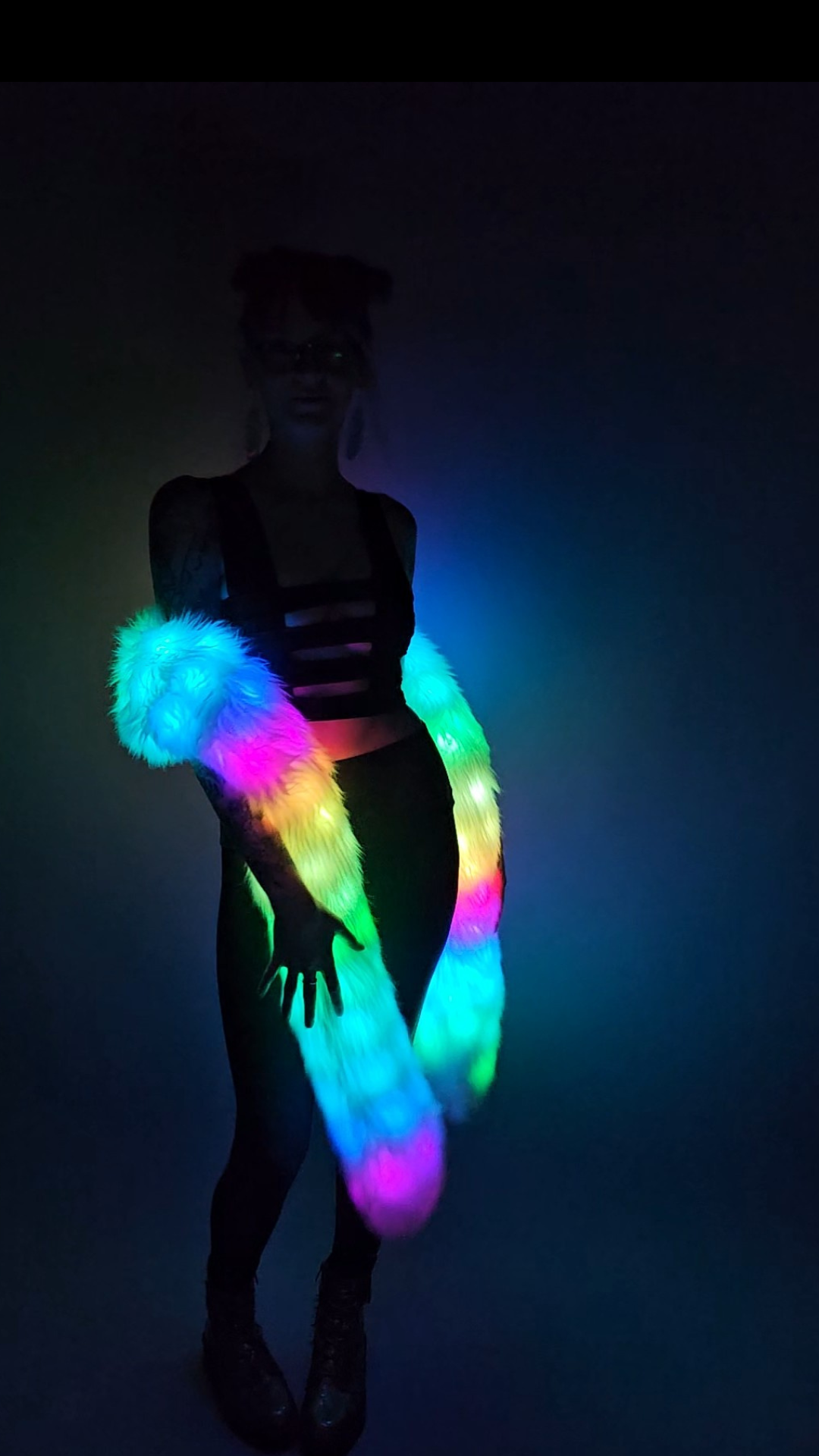 Woman wearing a white faux fur Glow Worm scarf with multicolor LEDs.