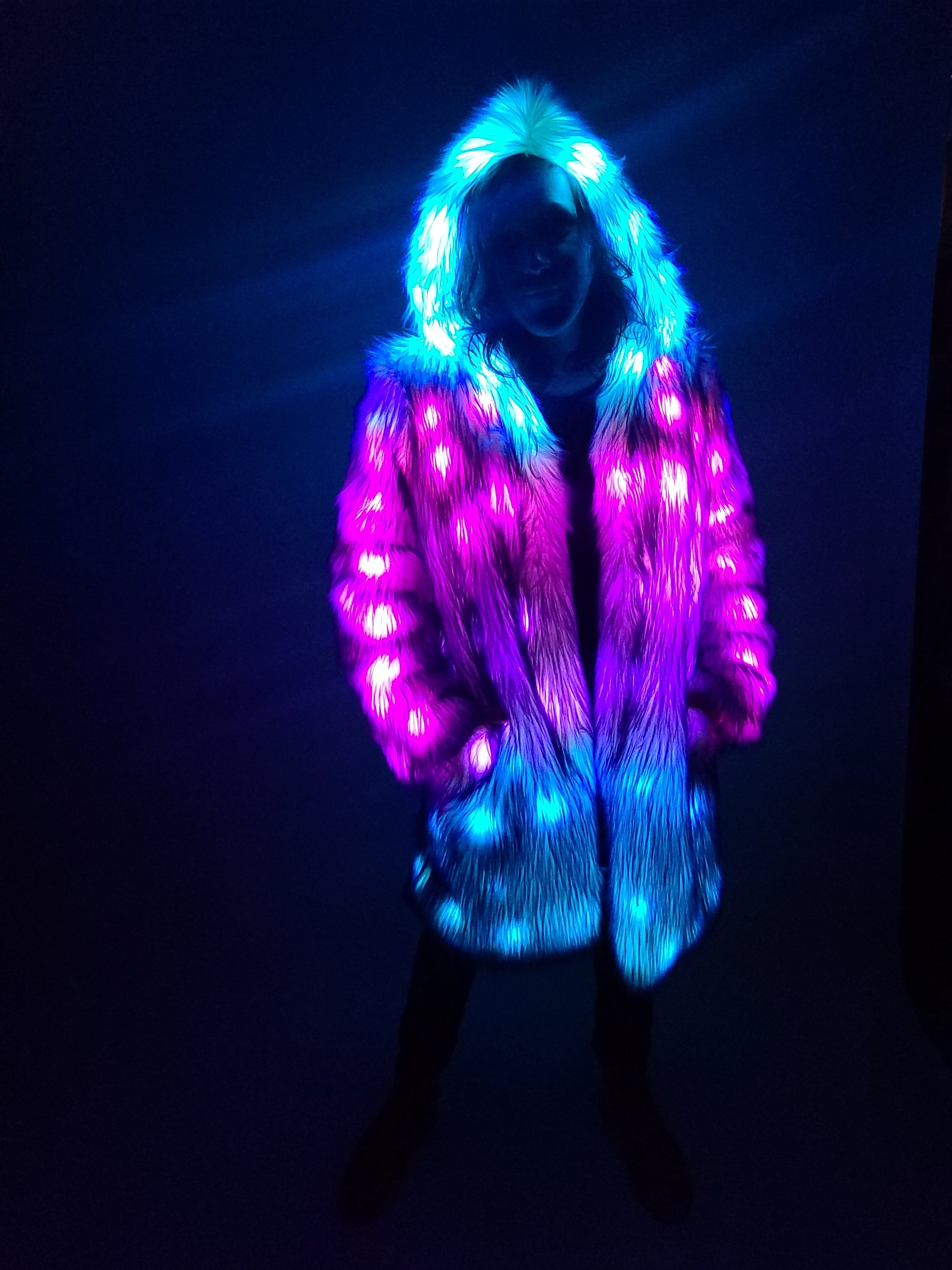 Man wearing a purple faux fur ciat illuminated with colorful leds.