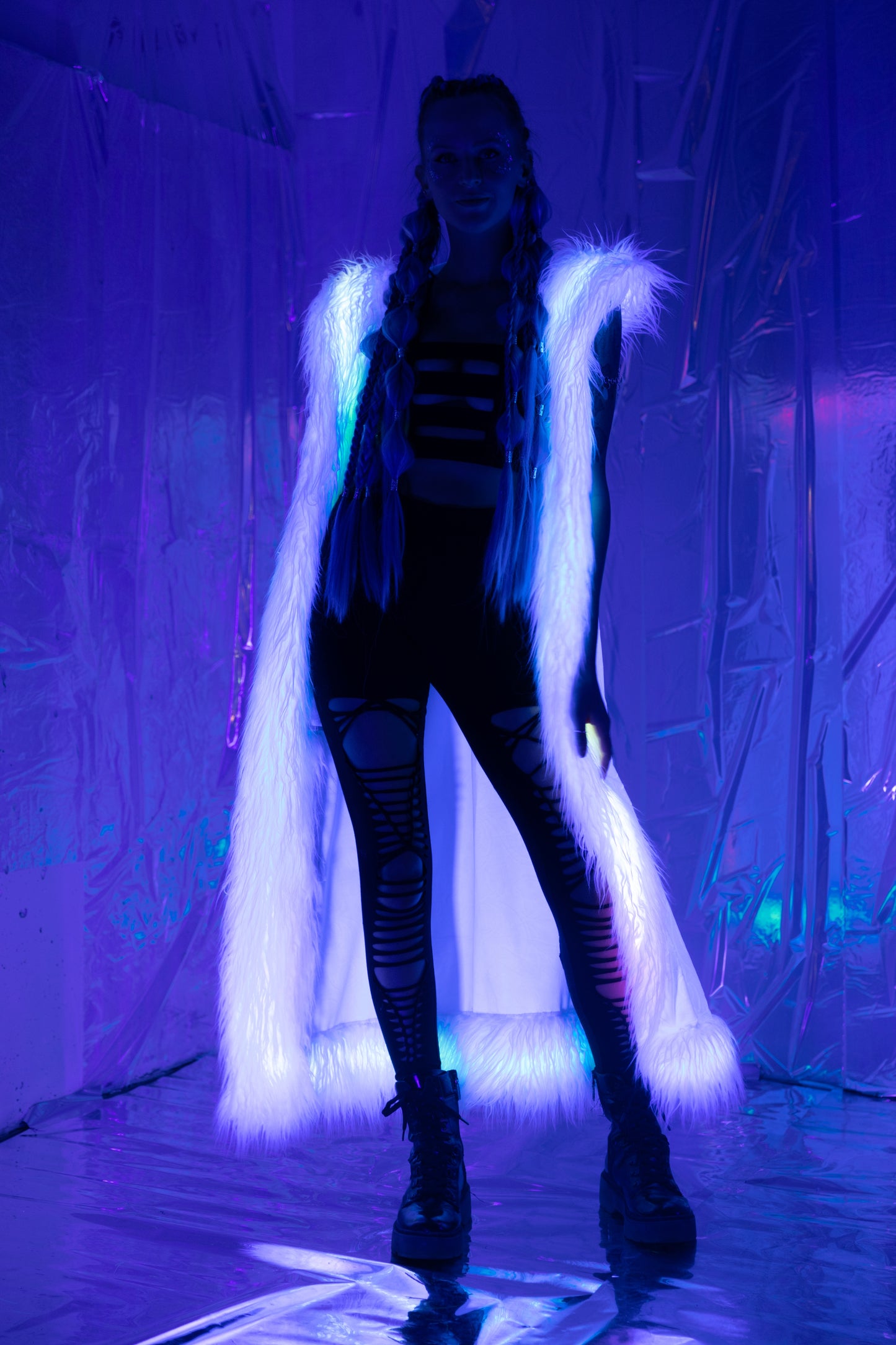 Long white velvet duster vest with white faux fur trim viewed with blacklight.