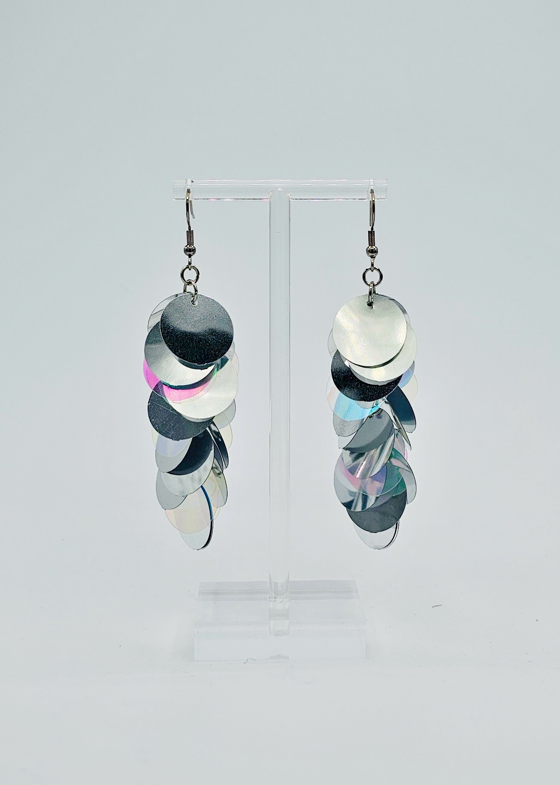 Silver iridescent sequin earrings on white background