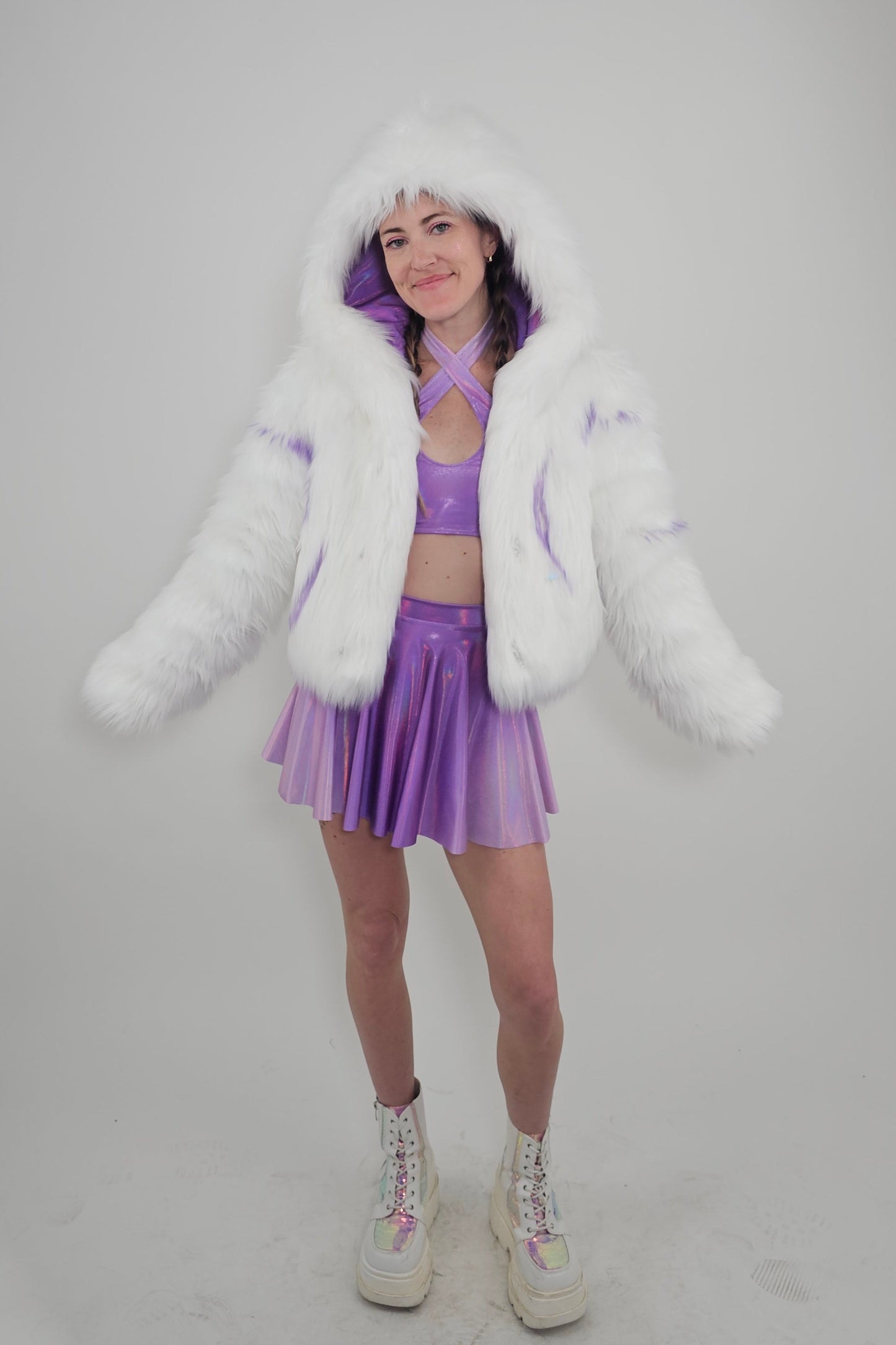 Model wearing white faux fur coat and lavender outfit