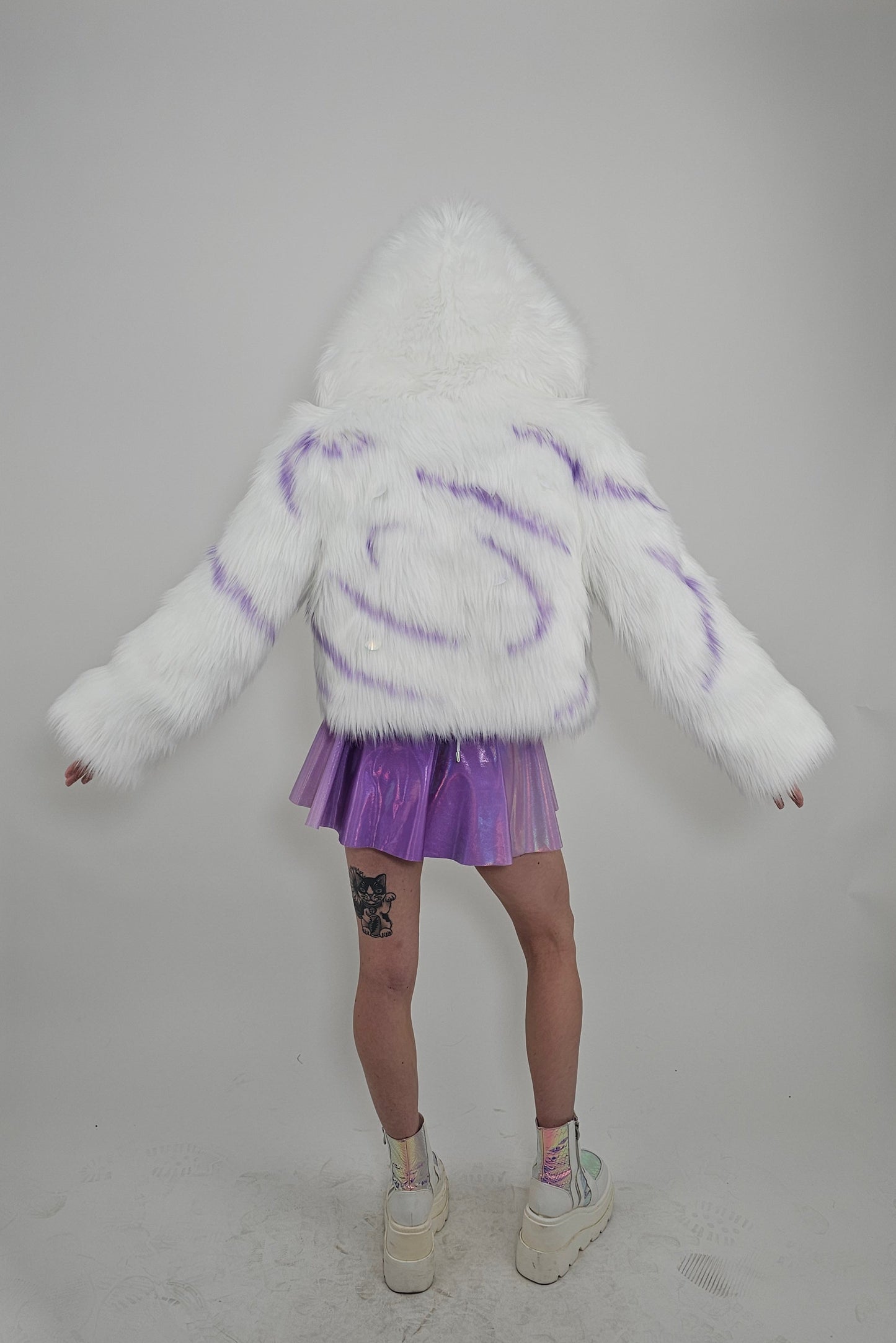 Model wearing white faux fur coat and lavender outfit