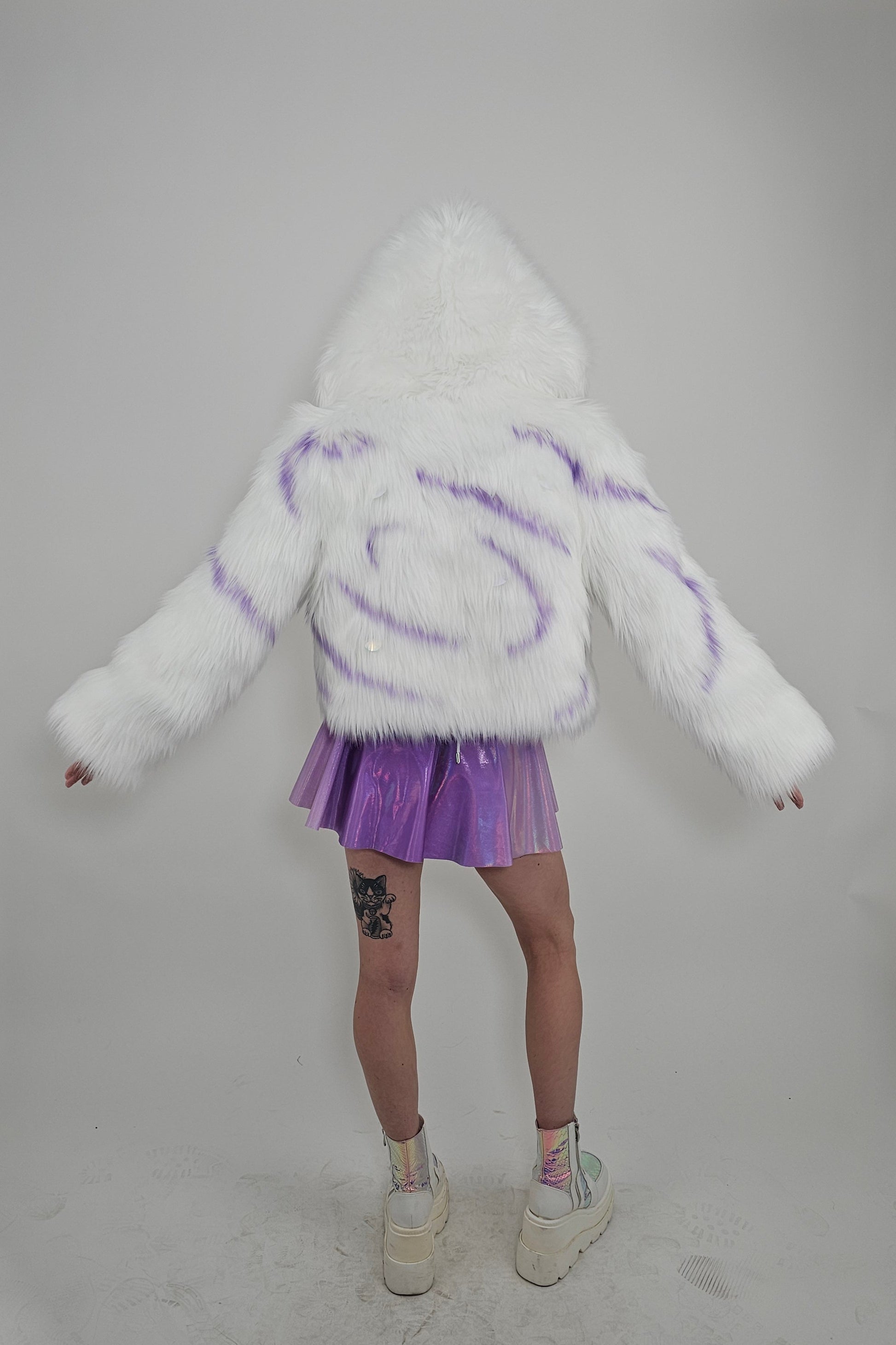 Model wearing white faux fur coat and lavender outfit