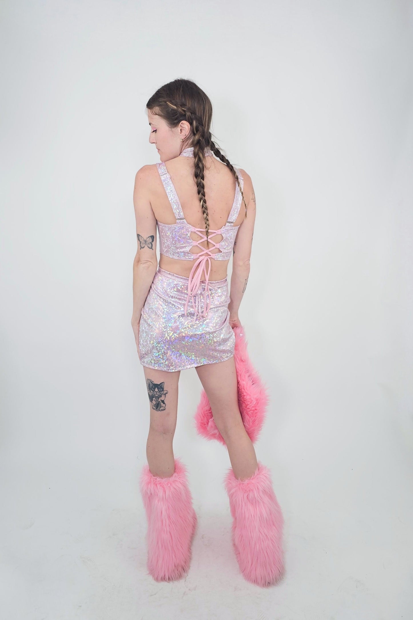 model wearing light pink skirt, top, and matching faux fur accessories