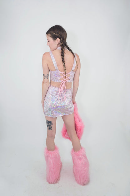 model wearing light pink skirt, top, and matching faux fur accessories