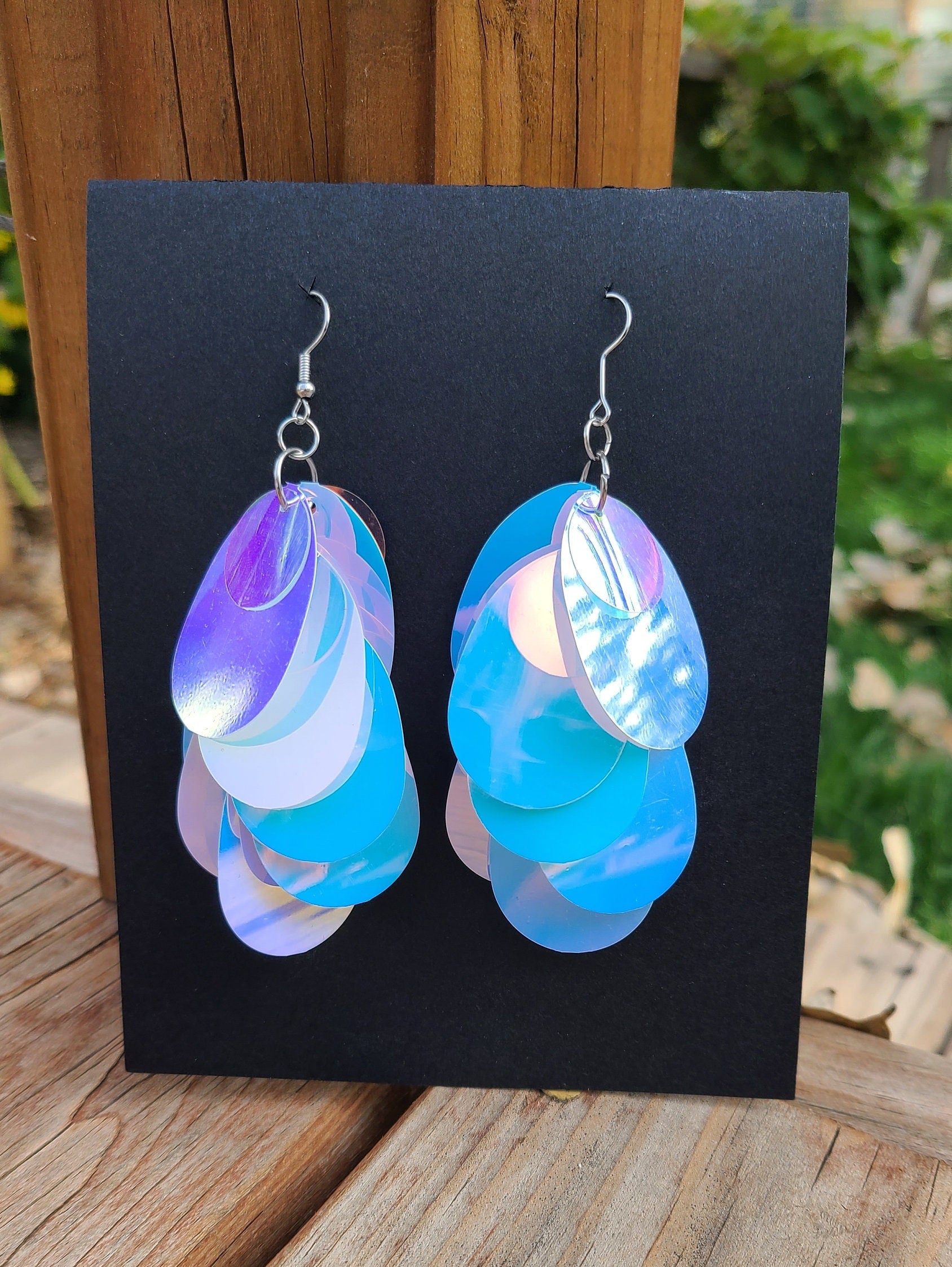 Blue iridescent teardrop shaped sequin earrings with silver hardware.