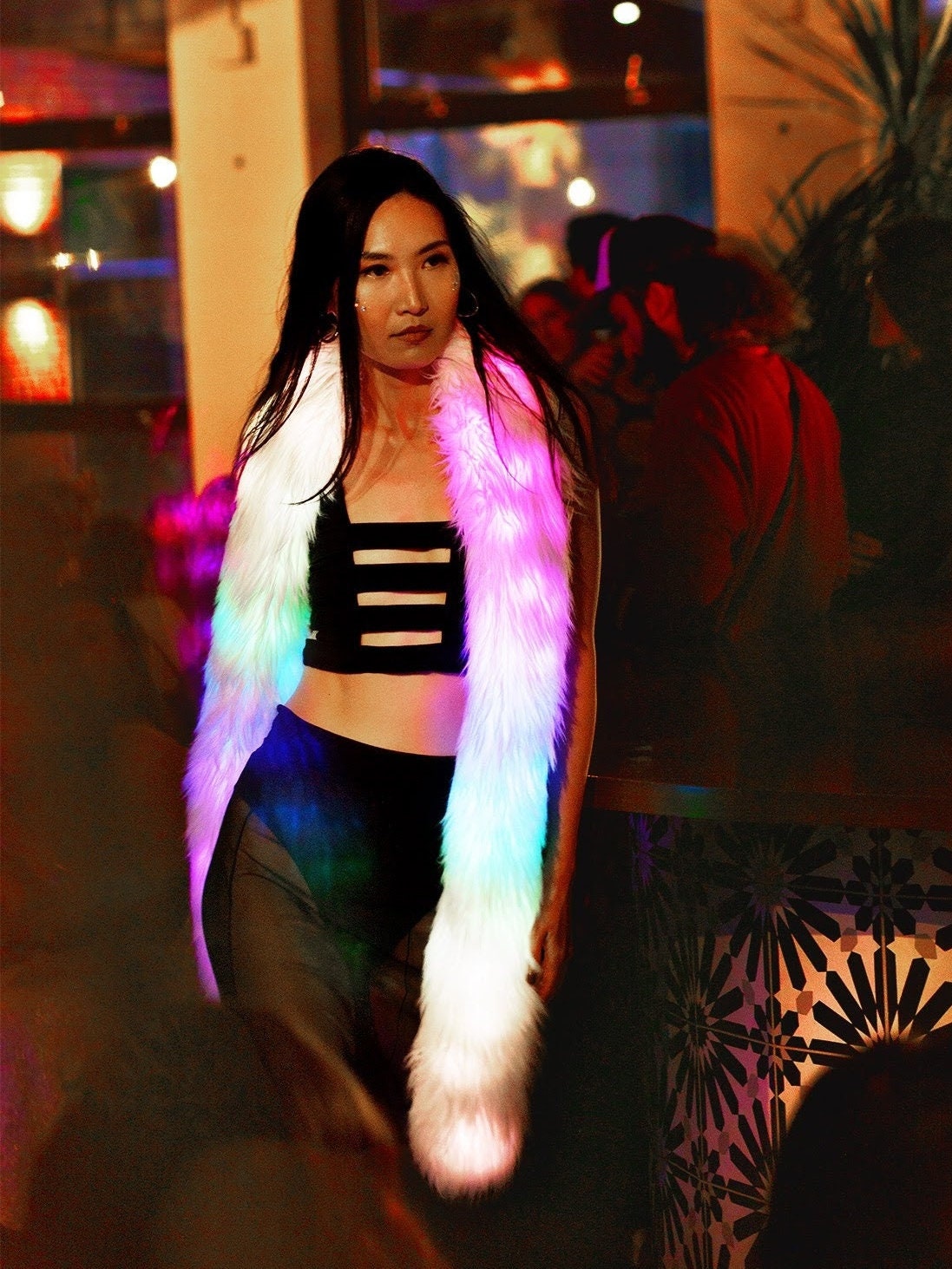 Model wearing cage bralette, a black bra top with horizontal straps, and led glow worm.