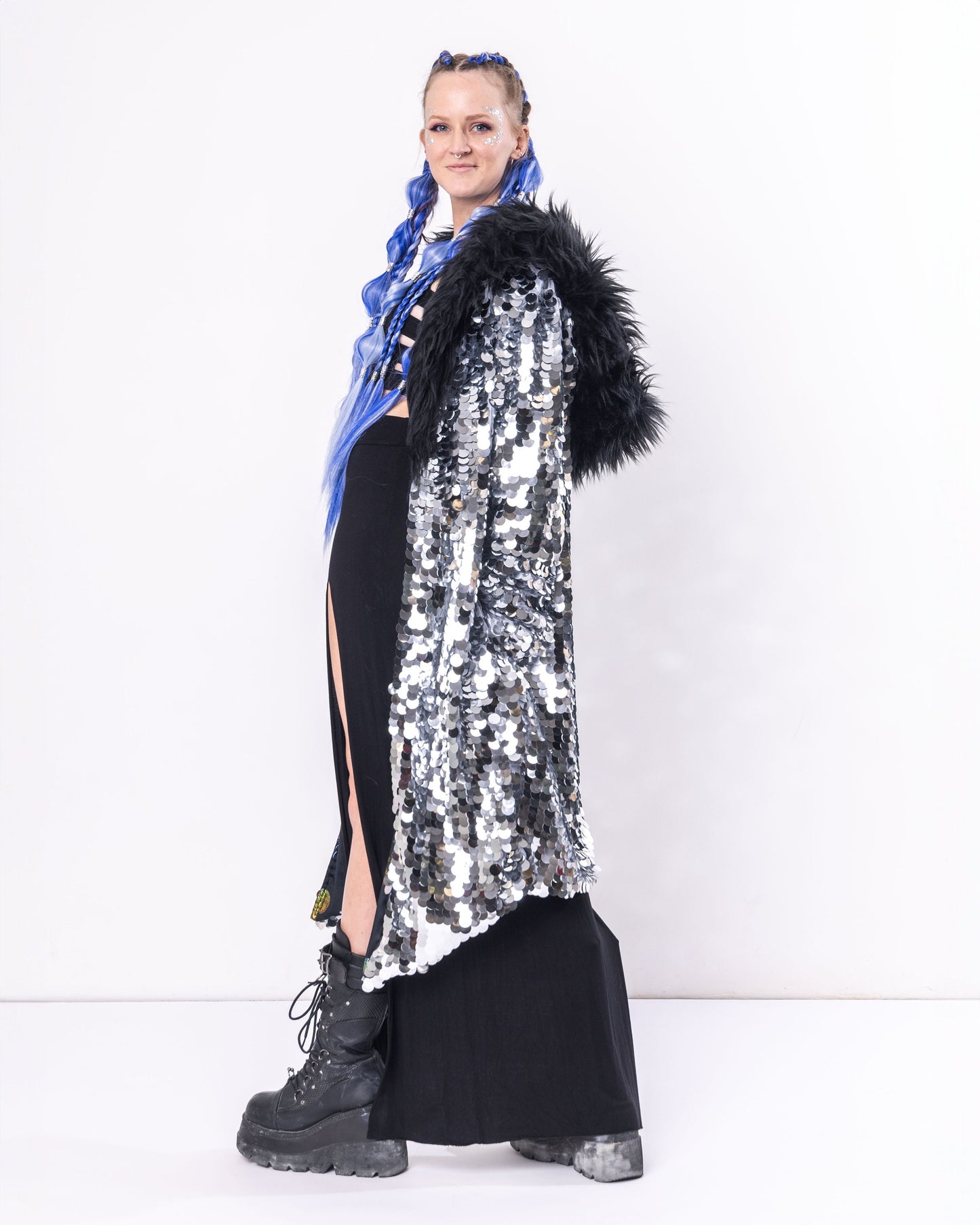 Model wearing Long coat made with silver sequins and black faux fur trim.