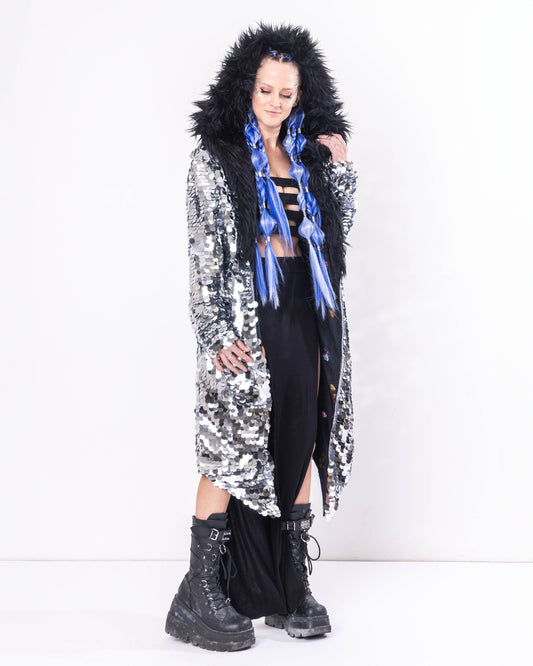 Model wearing Long coat made with silver sequins and black faux fur trim.